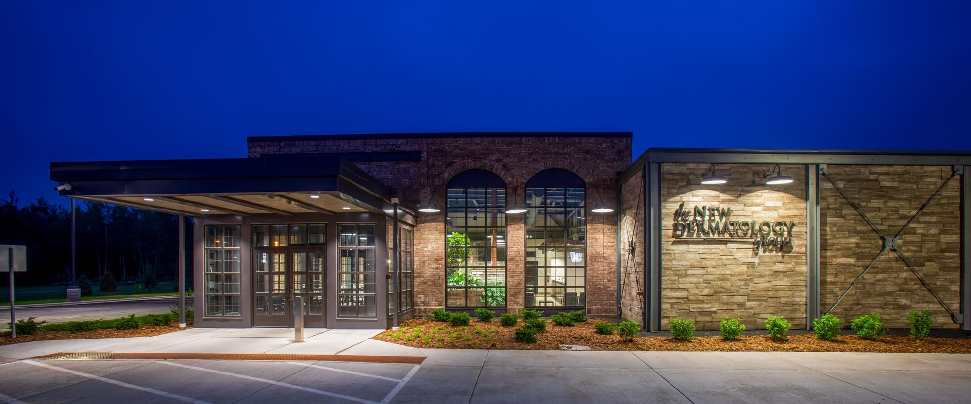 Commercial property photo of a modern restaurant with large windows, stone accents, dusk lighting, and professional landscaping. Commercial property photo of a modern restaurant with large windows, stone accents, dusk lighting, and professional landscaping.